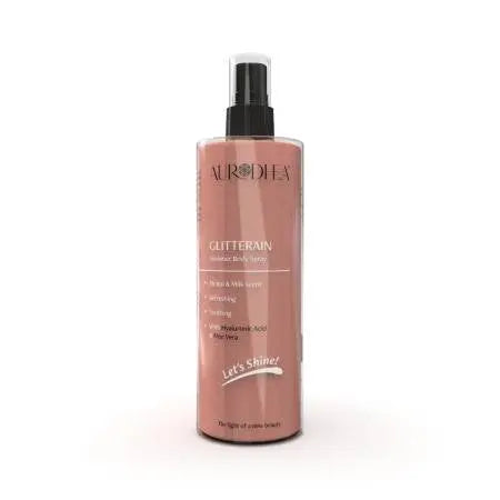 Spray corporel doré Glitterain Essencelle par Chogan avec parfum de monoï et lait, flacon de 150 ml visible.