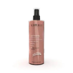 Spray corporel doré Glitterain Essencelle par Chogan avec parfum de monoï et lait, flacon de 150 ml visible.